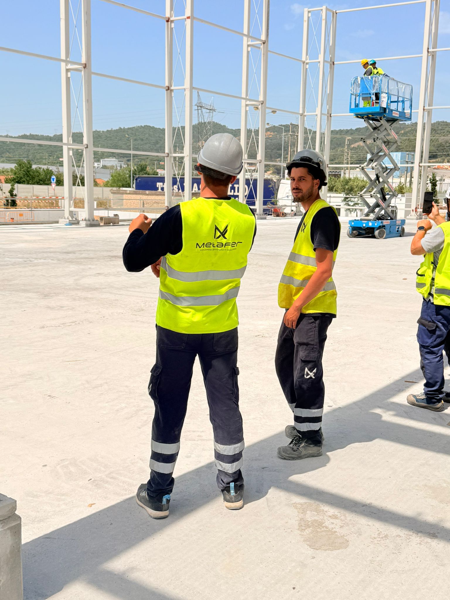 Équipe sur chantier avec EPI et coordination en hauteur.